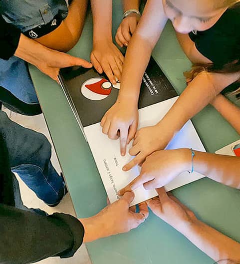 Fin. A moins que... Enfants lisant un livre tactile avec leurs doigts