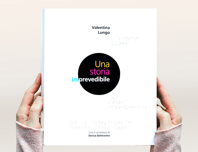 Le livre tactile Una storia imprevedibile tenue dans les mains