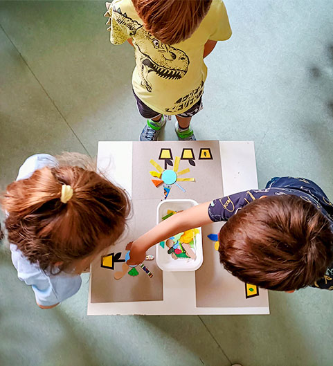 Les tournesols et d'autres fleurs. Enfants qui jouent avec un tableau tactile