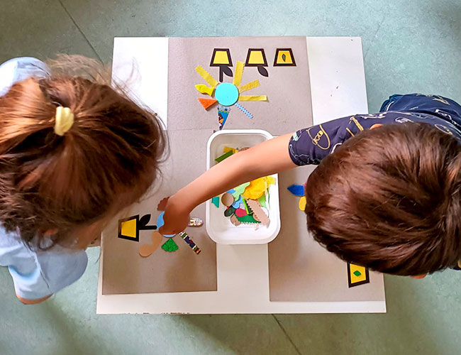 Les tournesols et d'autres fleurs. Enfants qui jouent avec un tableau tactile