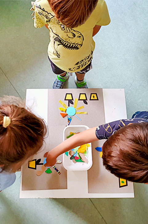 Les tournesols et d'autres fleurs. Enfants qui jouent avec un tableau tactile